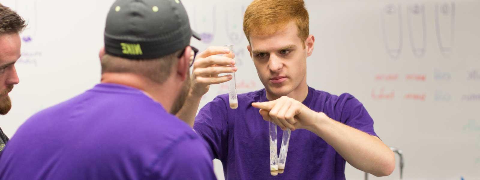 group of students concentrate on chemistry experiment
