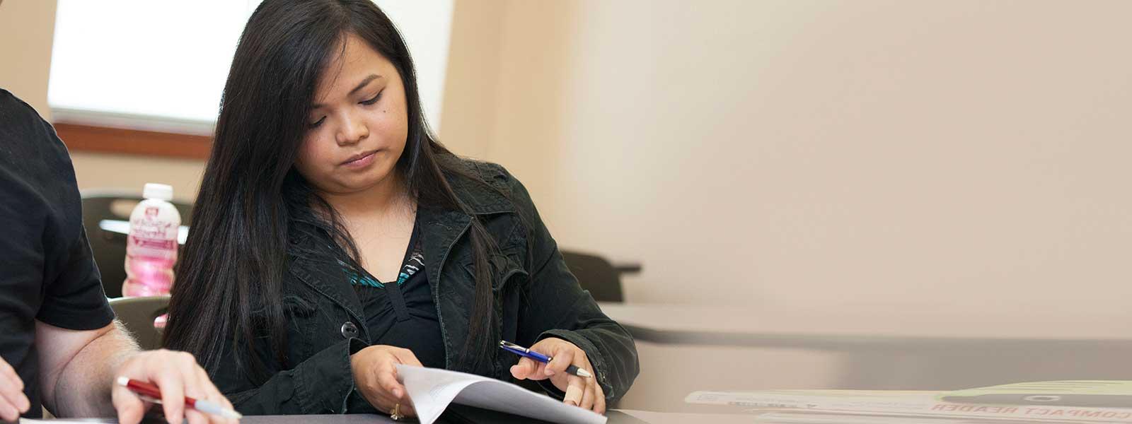 female student looks over notes